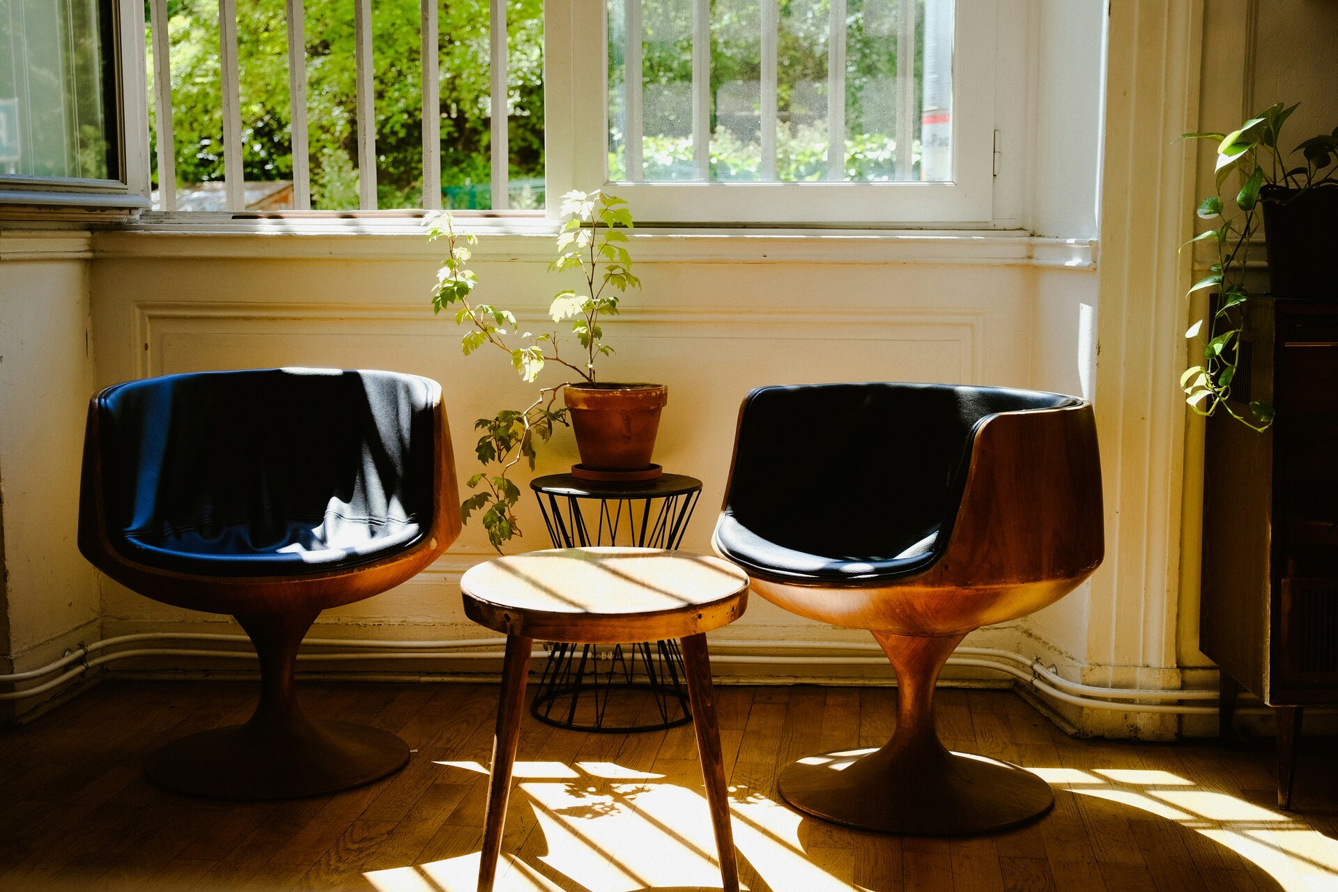 Two chairs with a small table in a sunlit room