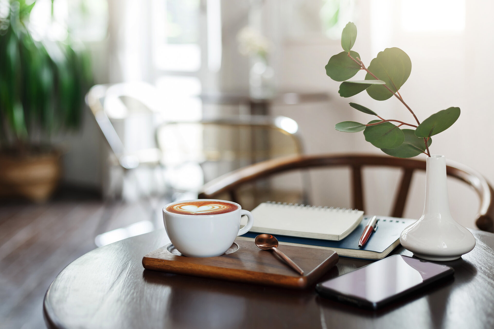 Cozy cafe table with latte and notebook